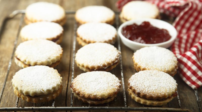 Linzer-style holiday sandwich cookies filled with jam and dusted with powdered sugar.